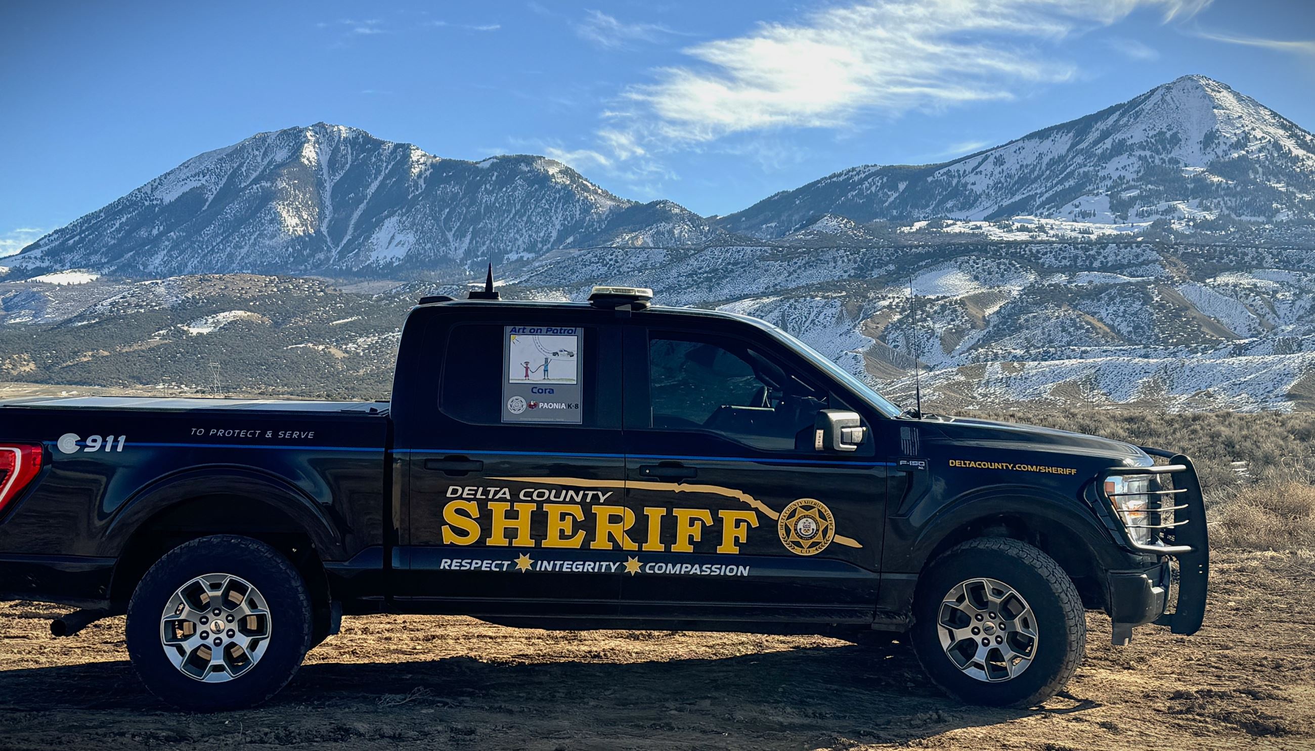 Delta County Sheriff's Office black F150 patrol truck parked in front of Mt Lamborn with snow