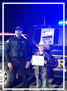 Deputy Middleton with Zavier in front of patrol truck with art 