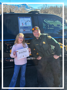 Deputy Granger with Cora in front of patrol truck with art 